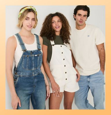 Friends standing against a wall wearing Lee workwear.