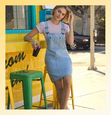 Woman standing against a wall wearing Lee womens wide leg jeans.