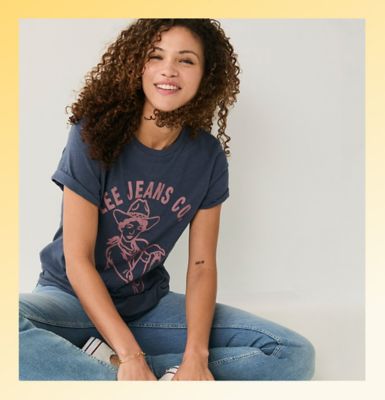 Friends standing against a wall wearing Lee tees.