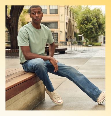 Man sitting on a city sidewalk wearing Lee relaxed fit jeans