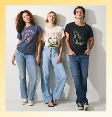 Friends standing against a wall wearing Lee tees.