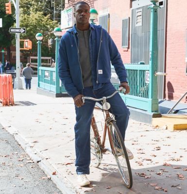 Guy on bike in the city wearing Lee SoftAge Denim.